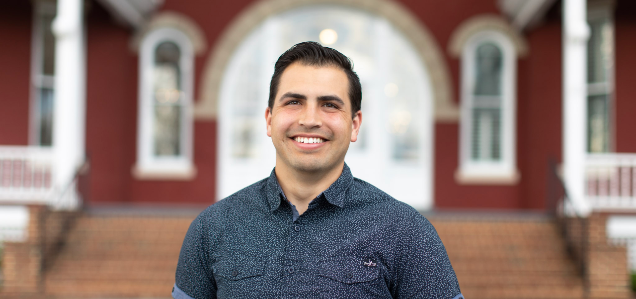 Man smiling in front of Main Hall