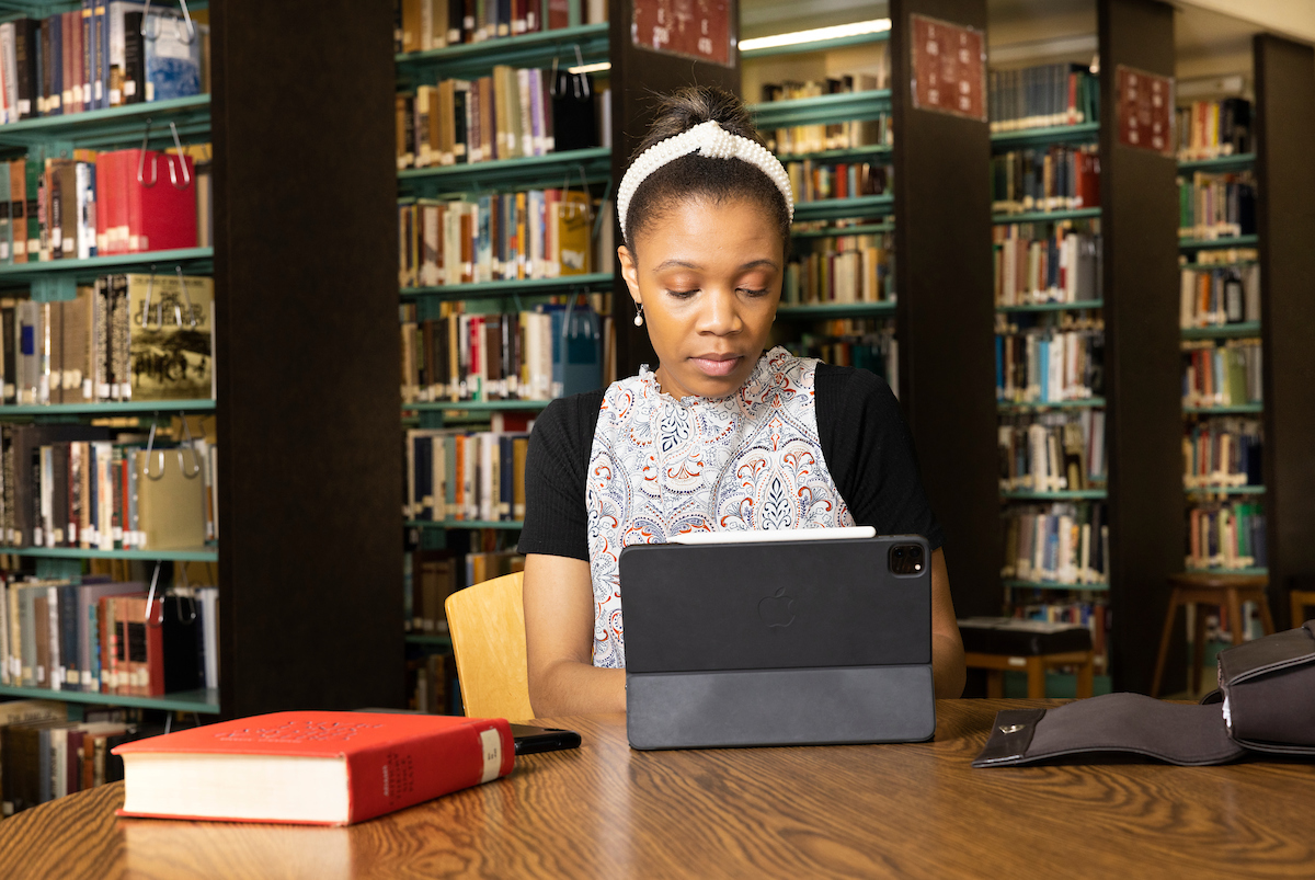 Student with iPad in a library