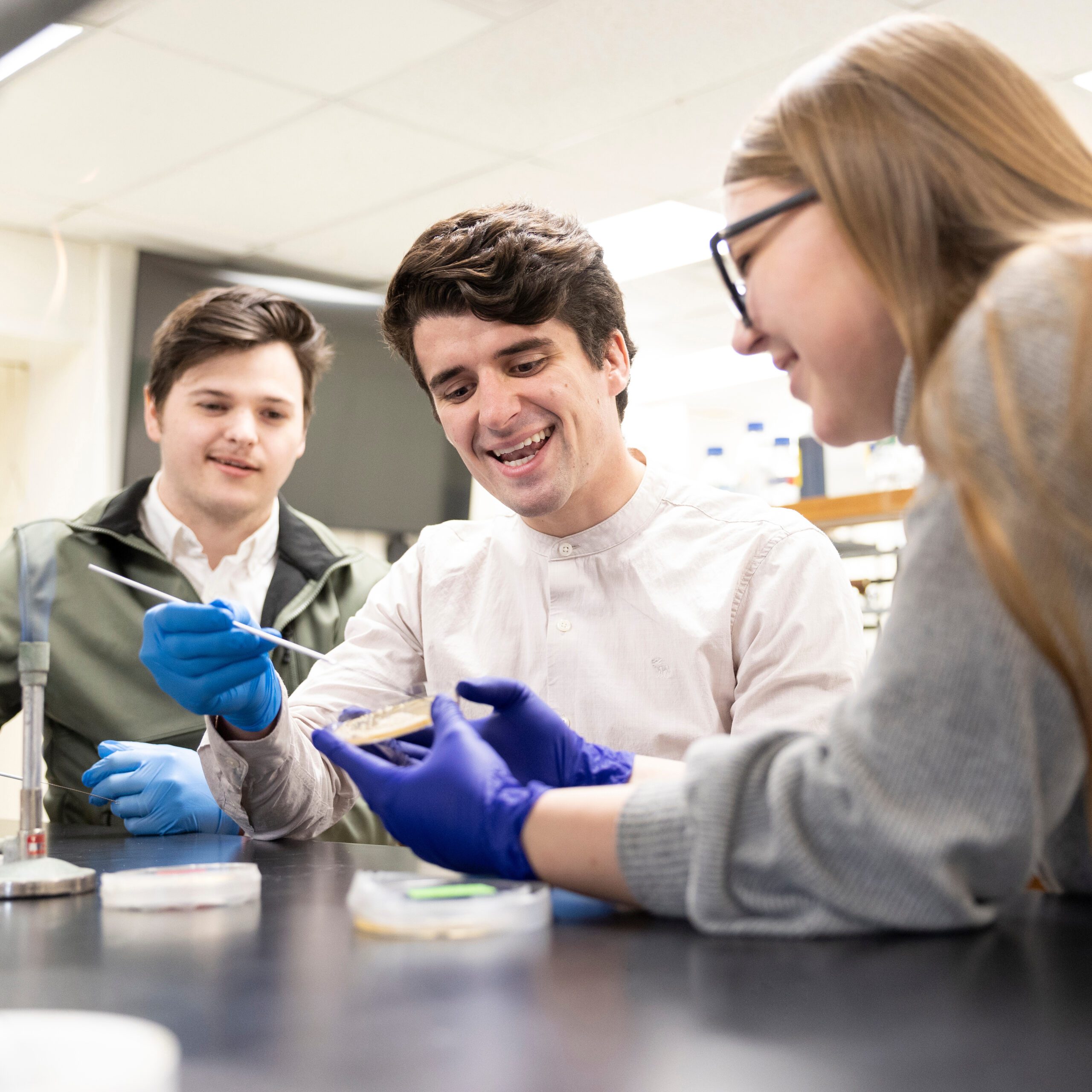 Students working in lab with a petri dish.