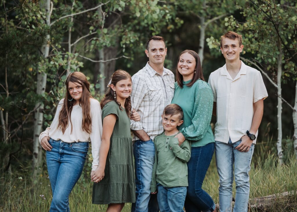 A family stands in the woods